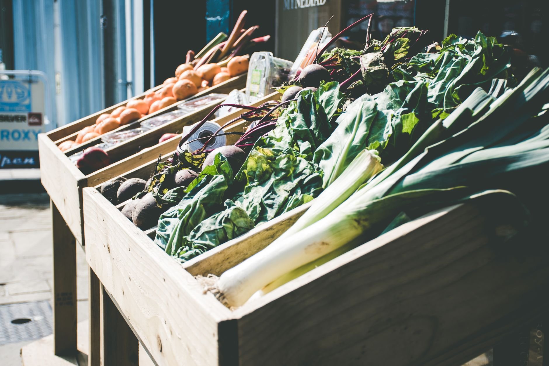 Array of fresh green vegetables at an outdoor farmers market